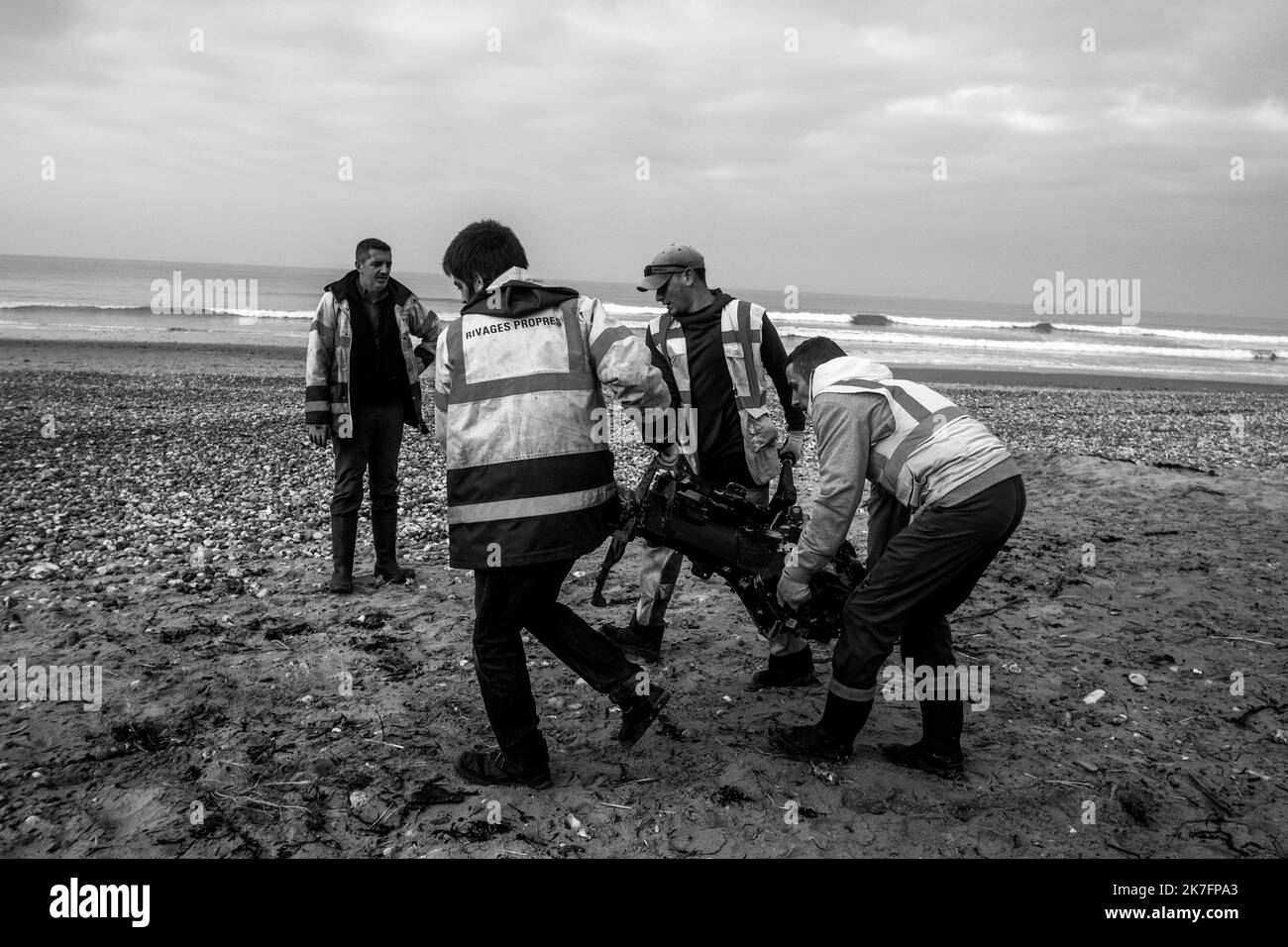 ©Michael Bunel / Le Pictorium/MAXPPP - Michael Bunel / Le Pictorium - 15/11/2021 - Frankreich / Haut de France / Calais - des hommes d'une Association de nettoyage du rivage portent un moteur de bateau afin que celui ci soit recupere par les Services Competent de la mairie de Wimereux. November 2016, la «Jungle» de Calais, plus Grand bidonville d'Europe, etait evakuee. Cinq ans apre`s, les Exiles sur la Route de la Grande Bretagne sont toujours la` et des campements naissent regulie`rement entre Calais et Grande-Synthe. Seule nouveaute, la Police qui les demante`le tous les deux trois jours pour Stockfoto